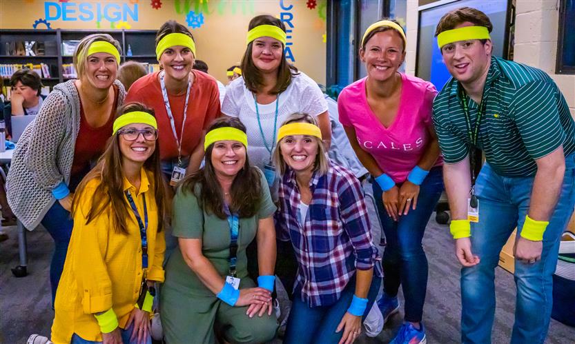 Teachers pose while wearing neon sweatbands